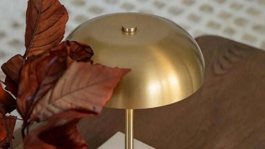 Soft cloth cleaning a brass-finish lamp beside a linen shade and marble base