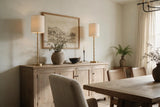 Pair of Aurelia brushed brass buffet lamps framing artwork on a dining room sideboard