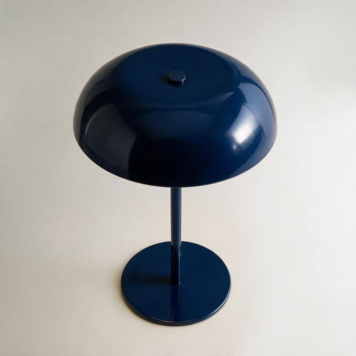 Glossy navy cordless mushroom table lamp shown from an elevated angle
