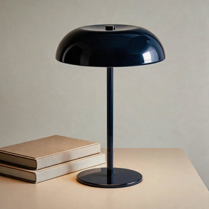 Navy cordless mushroom table lamp styled beside stacked cream books