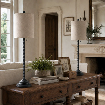 Lampworks black candlestick buffet lamps on a console table behind a living room sofa