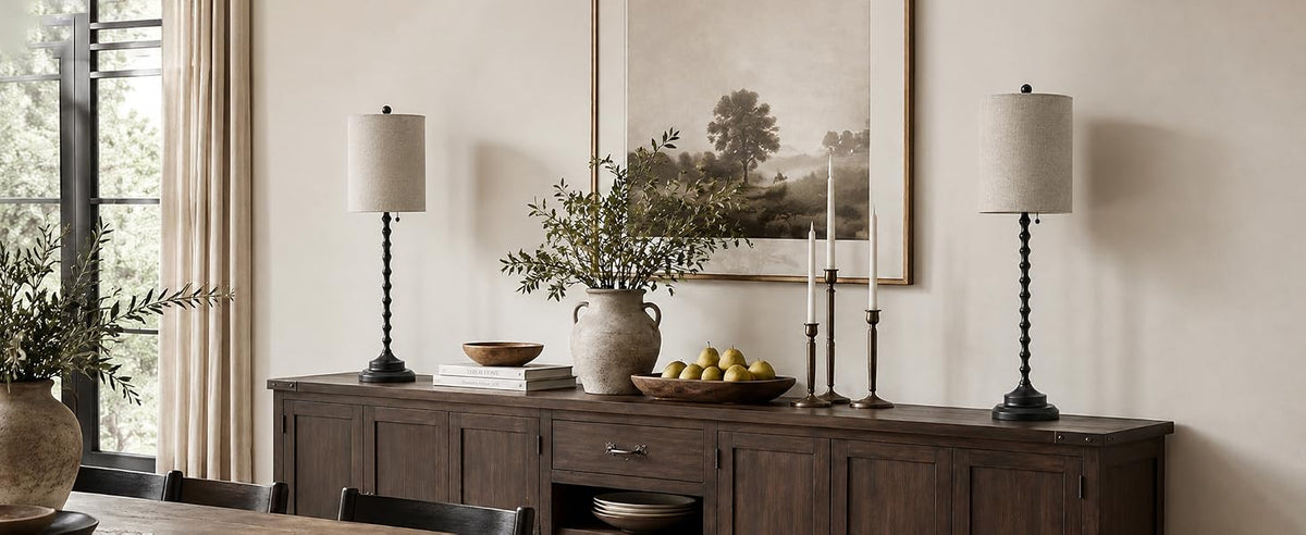 Two Lampworks black spindle buffet lamps with linen shades on a wooden sideboard in a farmhouse-style dining room.