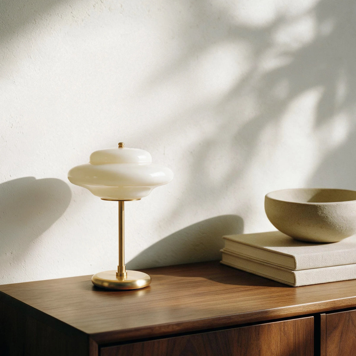 Unlit Lampworks glass table lamp with a milky white shade on a sunlit wood sideboard