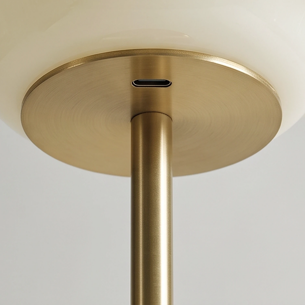 Close-up of the USB-C port beneath the opal glass shade of a Lampworks glass table lamp