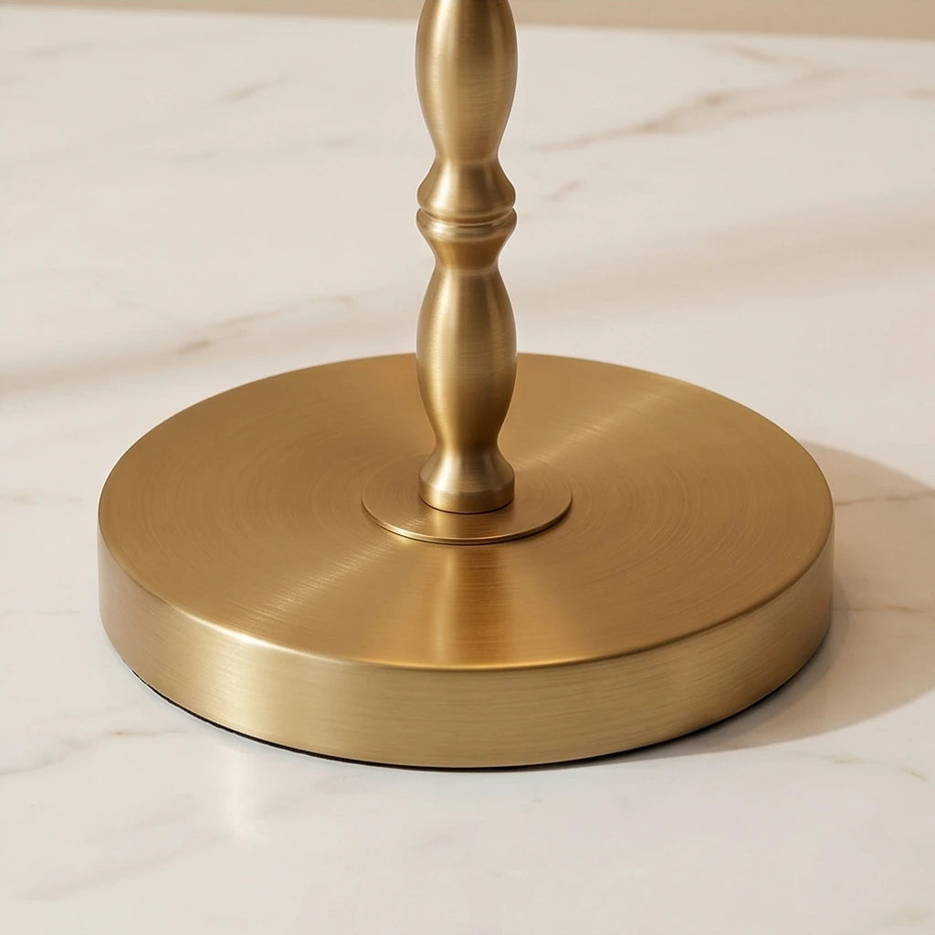 Close-up of the Aurelia buffet lamp's round brushed brass base and turned metal stem.